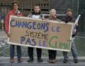 Кліматичні активісти тримають плакат "Міняй систему, а не клімат!" під час зустр